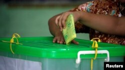 FILE - A voter casts her ballot in a by-election in Yangon, Myanmar, Nov. 3, 2018.