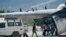 Des personnes chargent des fournitures d'urgence de Médecins Sans Frontières dans un hélicoptère des Nations Unies à destination de la ville ravagée par le séisme Les Cayes, à l'aéroport Toussaint Louverture à Port-au-Prince, Haïti, le 15 août 2021. (AP Photo/Fernando Llano)