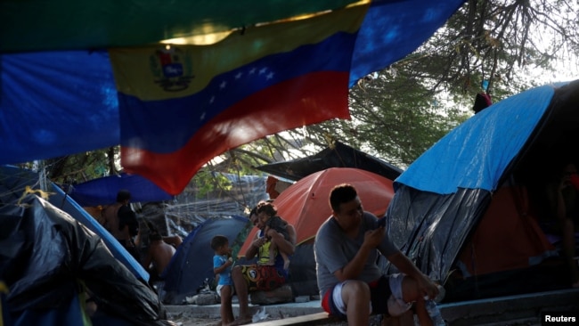 Los solicitantes de asilo venezolanos esperan para intentar cruzar a los EE. UU. mediante una cita a través de la aplicación de Aduanas y Protección Fronteriza, llamada CBP One, en un campamento improvisado en Matamoros, México, el 20 de junio de 2023.