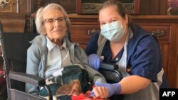 Recovered COVID-19 patient Connie Titchen, 106, is pictured with Sister Kelly Smith in Birmingham, central England, April 15, 2020. (Sandwell and West Birmingham NHS Trust photo)