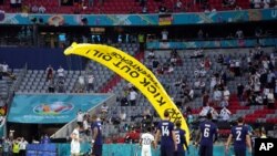 A Greenpeace paraglider lands on the pitch before the Euro 2020 soccer championship group F match between France and Germany at the Allianz Arena in Munich, Germany, June 15, 2021.