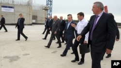 From right: Vice Premier Dmitry Rogozin, Russian Space Agency chief Oleg Ostapenko, Russian President Vladimir Putin walk during a visit to a construction site of Vostochny Cosmodrome, in the Amur region, Russia, Sept. 2, 2014.