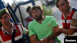 FILE - Turkish gendarmeries escort one of the 11 fugitive commandos, who were involved in a failed coup attempt, at the police headquarters in Mugla, Turkey, Aug. 1, 2016. 