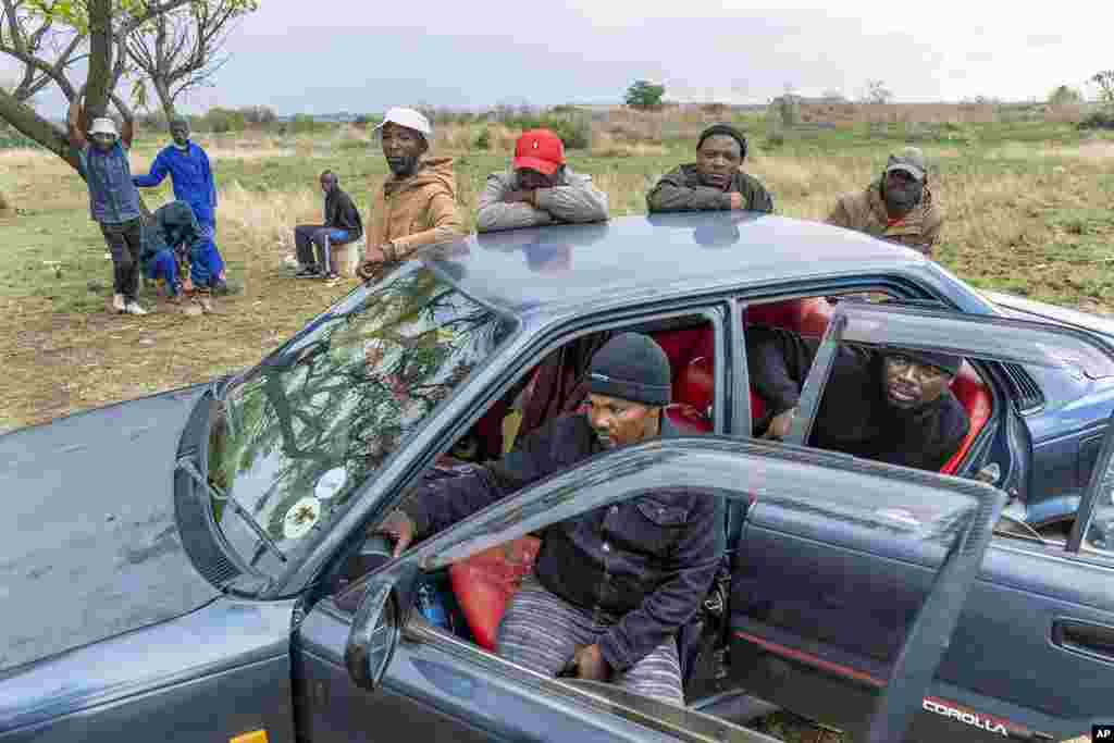 Relatives of miners and community members wait at a mine shaft where illegal miners are trapped in a disused mine in Stilfontein, South Africa.