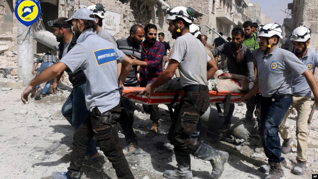 FILE - White Helmets rescuers work the site of airstrikes in the al-Sakhour neighborhood of the rebel-held part of eastern Aleppo, Syria, Sept. 21, 2016.