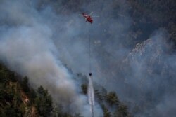 A helicopter participates in a wildfire extinguishing operation, in Koycegiz, Mugla province, Turkey, Aug. 9, 2021.