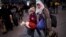 A Syrian girl carries her dolls as refugees and migrants arrive aboard a passenger ferry at the port of Piraeus, near Athens, Greece, Jan. 13, 2016. 