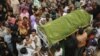 Relatives and residents carry the coffin of a woman who was killed in a deadly blaze at a garment factory in Karachi, Pakistan, September 13, 2012.