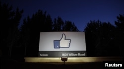 Le soleil se lève derrière l'entrée du siège de Facebook à Menlo Park