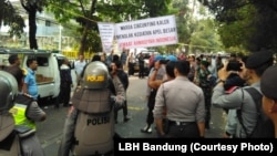 Kelompok yang mengatas-namakan warga menolak kegiatan Jalsah Salanah dari kelompok Ahmadiyah di Bandung akhir September 2018 sementara polisi nampak berjaga. (Courtesy: LBH bandung)