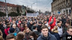 Protesters hold a banner reading "I do care about it" during a mass quiet march in Bratislava, Slovakia, March 23, 2018. Many thousands of Slovaks took to the streets in anti-government protests amid a continuing political crisis triggered by the recent slayings of an investigative reporter and his fiancee.