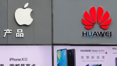 Biểu tượng của Apple và Huawei được trưng bày bên ngoài cửa hàng bán diện thoại di động tại Thâm quyến tỉnh Quảng Đông (ảnh chụp ngày 7/3/2019)
