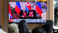 A TV screen shows a file image of North Korean leader Kim Jong Un, right, and Russian President Vladimir Putin in Pyongyang, during a news program at the Seoul Railway Station in Seoul, South Korea, Nov. 12, 2024.