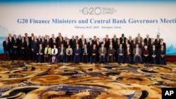 Officials led by host country officials Chinese Finance Minister Lou Jiwei, center left in front, and People's Bank of China Governor Zhou Xiaochuan, center right in front, pose for a family photo of G20 Finance Ministers and Central Bank Governors Meeting at the Pudong Shangri-la Hotel in Shanghai, Feb. 27, 2016. 
