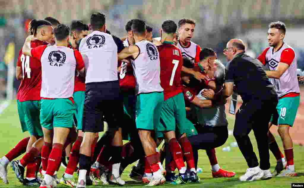Moroccan players celebrate scoring their first goal with teammates and coach Vahid Halilhodzic.