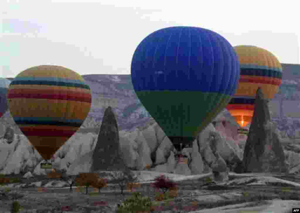 In this photo dated Nov. 15, 2010, hot air balloons rise into the morning sky at sunrise in Cappadocia, central Turkey. Formed by gas bubbling through ash, Cappadocia has become a favorite site for tourists in hot-air balloons who can slowly drift above t