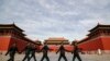 Soldiers wearing protective face masks march past the closed entrance gates to the Forbidden City, usually crowded with tourists before the new coronavirus outbreak in Beijing, Thursday, March 12, 2020. For most people, the new coronavirus causes…