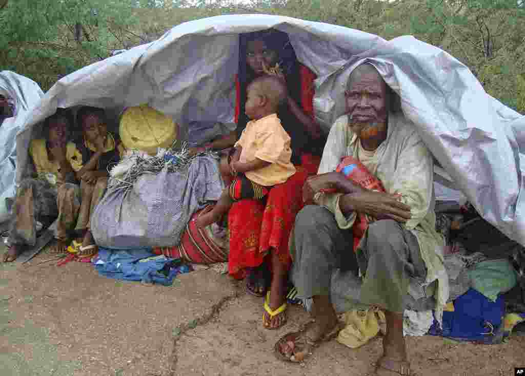 Displaced people sit with their packed belongings as they prepare to flee Badbado settlement after two groups of Somalia government soldiers clashed inside the camp in the capital Mogadishu, August 5, 2011. (Reuters)
