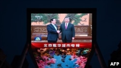一个大型屏幕显示官方中央电视台报道中国领导人会晤台湾前总统马英九。(2024年4月10日)