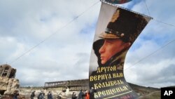 3월 18일 러시아의 크림반도 강제 병합 7주년을 맞아 세바스토폴 주민들이 블라디미르 푸틴 대통령의 대형 사진을 걸고 있다. 