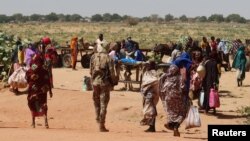 FILE - Families escaping Ardamata in West Darfur cross into Adre, Chad, after a wave of ethnic violence, November 7, 2023.