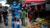 Seorang mengenakan kostum Transformers dan petugas lainnya mengingatkan warga agar tetap tinggal di rumah selama PSBB di Bandung, Jawa Barat (Foto: Antara/Reuters). 