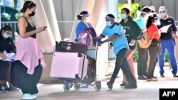 Des touristes arrivent à l'aéroport international Sir Seewoosagur Ramgoolam de Port Louis le 15 juillet 2021. 