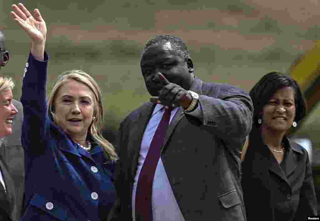 Ministro ugandês dos Negócios Estrangeiros, Okello Oryem, recebe Hillary Clinton no Aeroporto Internacional de Entebe.