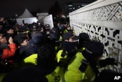 People try to enter as police officers stand guard in front of the National Assembly in Seoul, South Korea, Dec. 3, 2024.