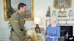 Britain's Queen Elizabeth II greets Corp. Ben Robert-Smith, from Australia, who was recently awarded the Victoria Cross, during an audience at Buckingham Palace in London, Nov.15, 2011. 