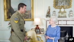 Ratu Inggris Elizabeth II menyapa Ben Robert-Smith, dari Australia, yang baru-baru ini dianugerahi Victoria Cross pada 2011. Hakim menyatakan ia secara tidak sah membunuh tahanan di Afghanistan.(Foto: AP)