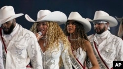 Beyoncé, en el centro a la izquierda, y su hija, Blue Ivy Carter, actúan durante el medio tiempo de un partido de fútbol americano de la NFL entre los Baltimore Ravens y los Houston Texans el 25 de diciembre de 2024, en Houston.