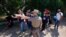 FILE - A Texas Department of Public Safety officer directs migrants who crossed the border and turned themselves in, in Del Rio, Texas, June 16, 2021.