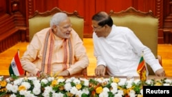 India's Prime Minister Narendra Modi (L) talks to Sri Lanka's President Maithripala Sirisena at the Presidential Secretariat in Colombo, March 13, 2015. 