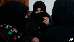 FILE - In this Feb. 18, 2019, photo, Alissa, who faced domestic violence, center, speaks during an interview with the Associated Press at a women's shelter office in Herat, Afghanistan.