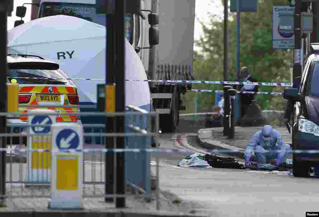 A police forensics officer investigates a crime scene where one man was killed in Woolwich, southeast London May 22, 2013.