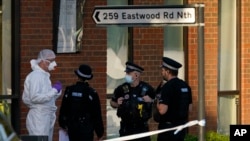 Police officers talk to a forensic technician at the scene outside the Belfairs Methodist Church, where British lawmaker David Amess died after being stabbed at a meeting with constituents, in Leigh-on-Sea, Essex, England, Oct. 15, 2021.