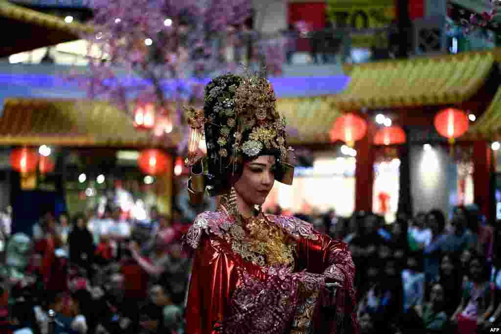 A performer dressed as Empress Huang of the China&#39;s Forbidden City takes part in a musical performance at a shopping mall in Kuala Lumpur to celebrate the upcoming Lunar New Year.