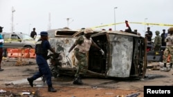 Petugas militer memindahkan mobil yang rusak di lokasi ledakan bom di Nyanya, Abuja, 2 Mei 2014.