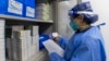 FILE - In this photo released by Xinhua News Agency, a pharmacist checks on a prescription at a community health service center in Shanghai, China, Jan. 8, 2023. 