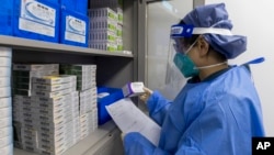 FILE - In this photo released by Xinhua News Agency, a pharmacist checks on a prescription at a community health service center in Shanghai, China, Jan. 8, 2023. 