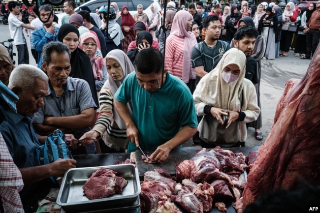 Para pembeli rela antre untuk membeli daging menjelang bulan puasa Ramadan di Banda Aceh, 27 Februari 2025, . (YASUYOSHI CHIBA/AFP)