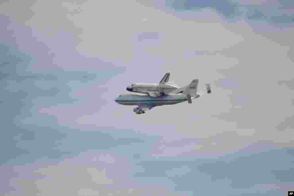 Space shuttle Discovery atop a 747 carrier jet flying over the National Mall in Washington, April 17, 2012. (VOA-M. Hishmeh)