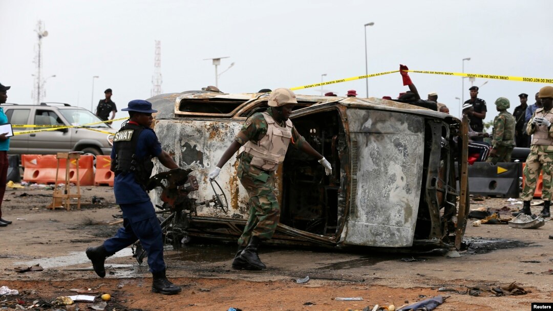 Petugas militer memindahkan mobil yang rusak di lokasi ledakan bom di Nyanya, Abuja, 2 Mei 2014.
