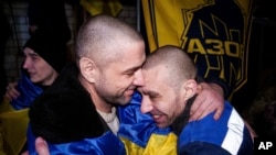 Ukrainian servicemen of the Azov Brigade hug each other after returning from captivity during a prisoner exchange between Russia and Ukraine, in Ukraine, Dec. 30, 2024.