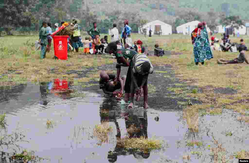 Congolese civilians who fled from Goma, wash their feet after arriving at a reception center in Rugerero near Gisenyi, in Rubavu district, Rwanda, Jan. 28, 2025. 