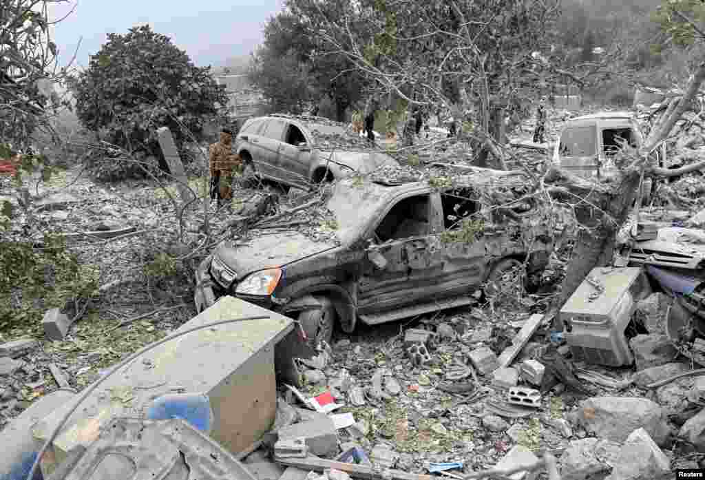 Lebanese army soldier stand near destroyed vehicles at a site damaged by an Israeli airstrike in the Christian-majority region of Aitou in north Lebanon.