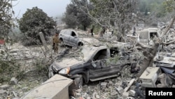 Lebanese army soldiers stand near destroyed vehicles at a site damaged by an Israeli airstrike in the Christian-majority region of Aitou in north Lebanon, the Lebanese health ministry said, Oct. 14, 2024. 