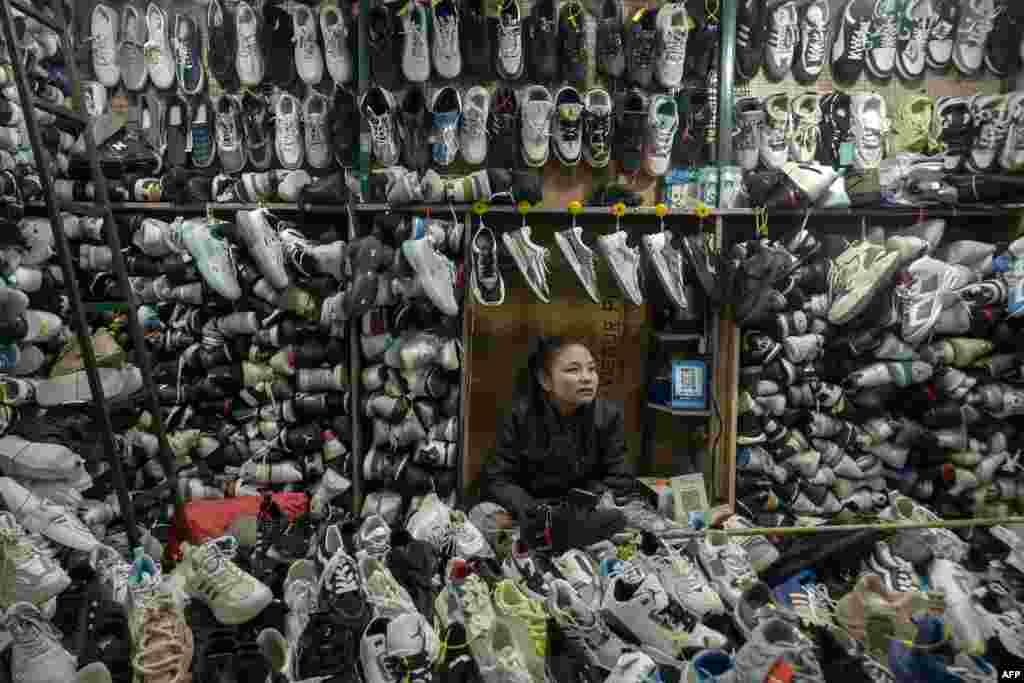 A shopkeeper selling shoes waits for customers at a market in Srinagar.