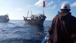 A boat carries Rohingya people stranded at sea, Indonesia, December 27, 2021, in this still image obtained from a social media video.